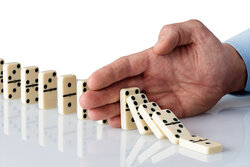 Hand stoppt Dominosteine