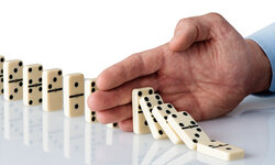 Konfliktmanagement-Training Hand stoppt Dominosteine